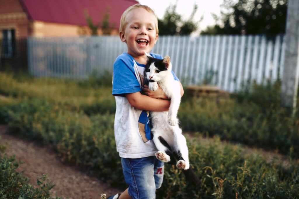 un enfant portant un chat abandonné